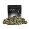 A pile of vibrant green cannabis buds in front of a black BOUTIQ brand pouch, which labels the product as 'Premium Flower 14g | 0.5oz' and 'INDOOR' with a CA cannabis symbol.